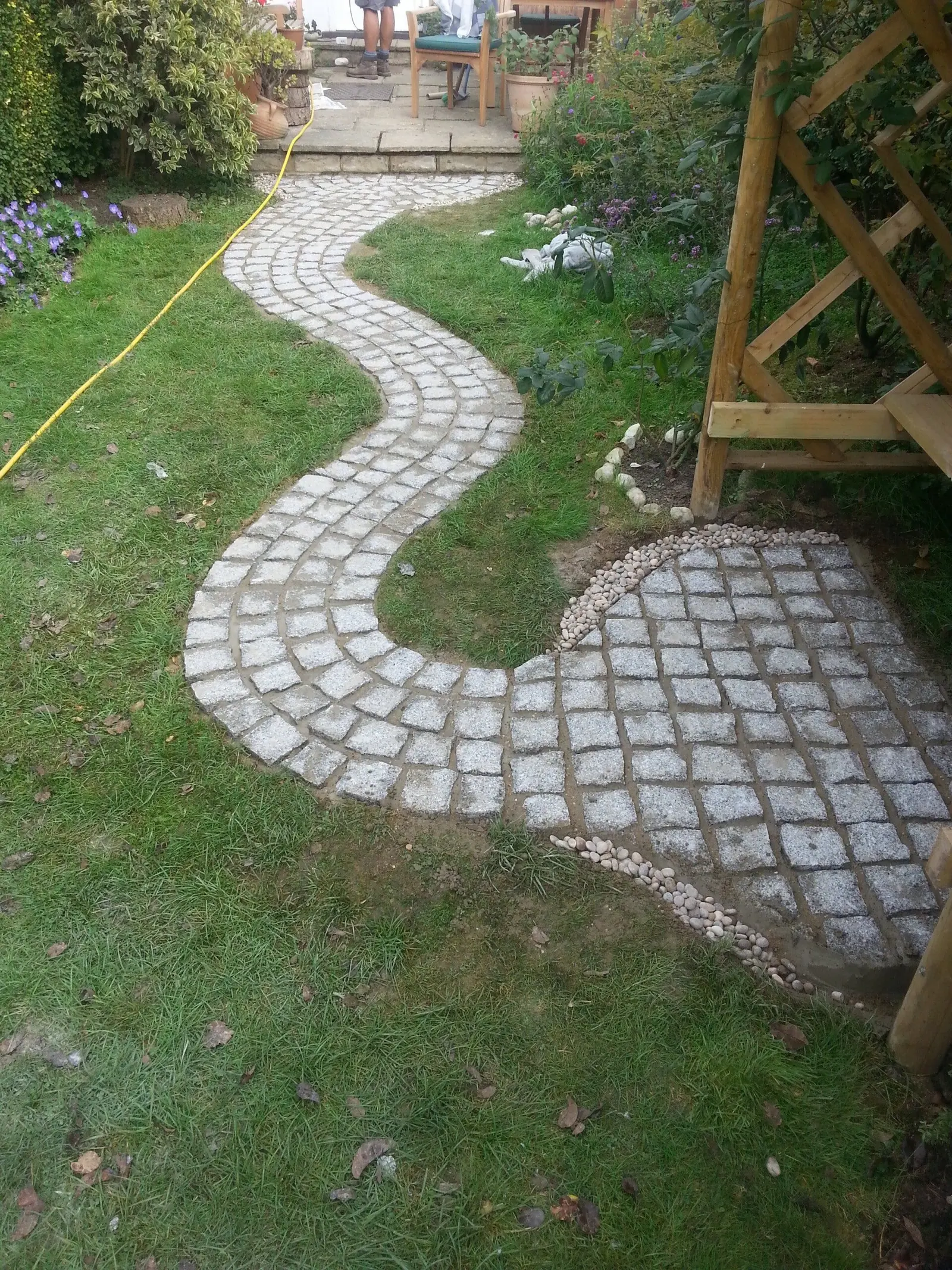 Finished curved cobble-sett path winding through a lawn