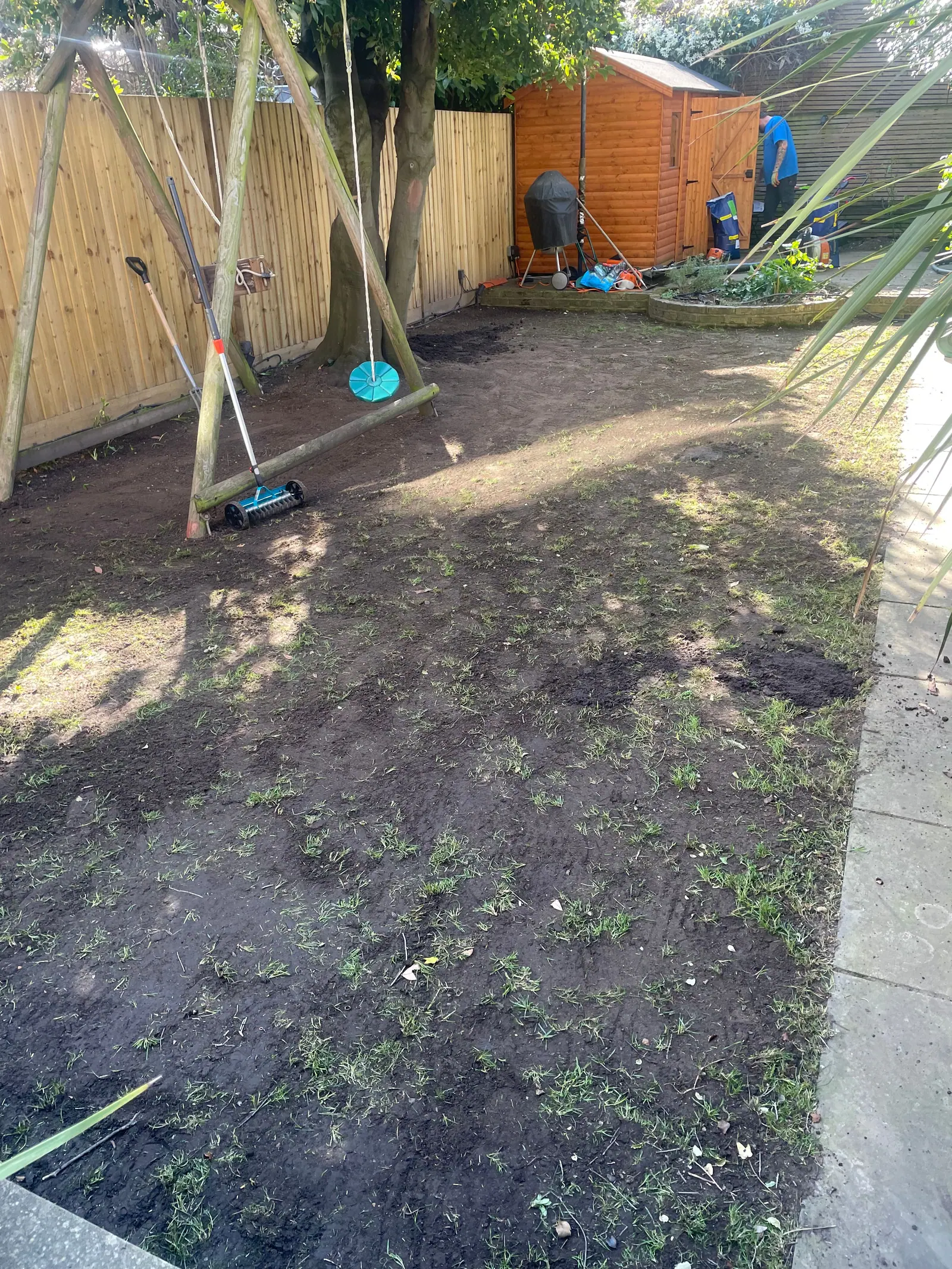 Garden levelled and prepared for turf beside new fencing, with the swing frame in place