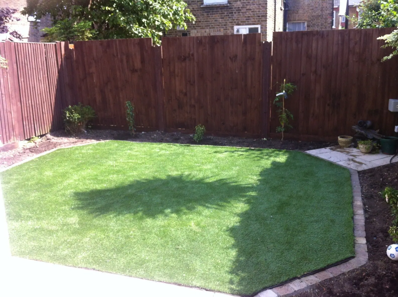 New turf laid in a back garden with new close-board fencing